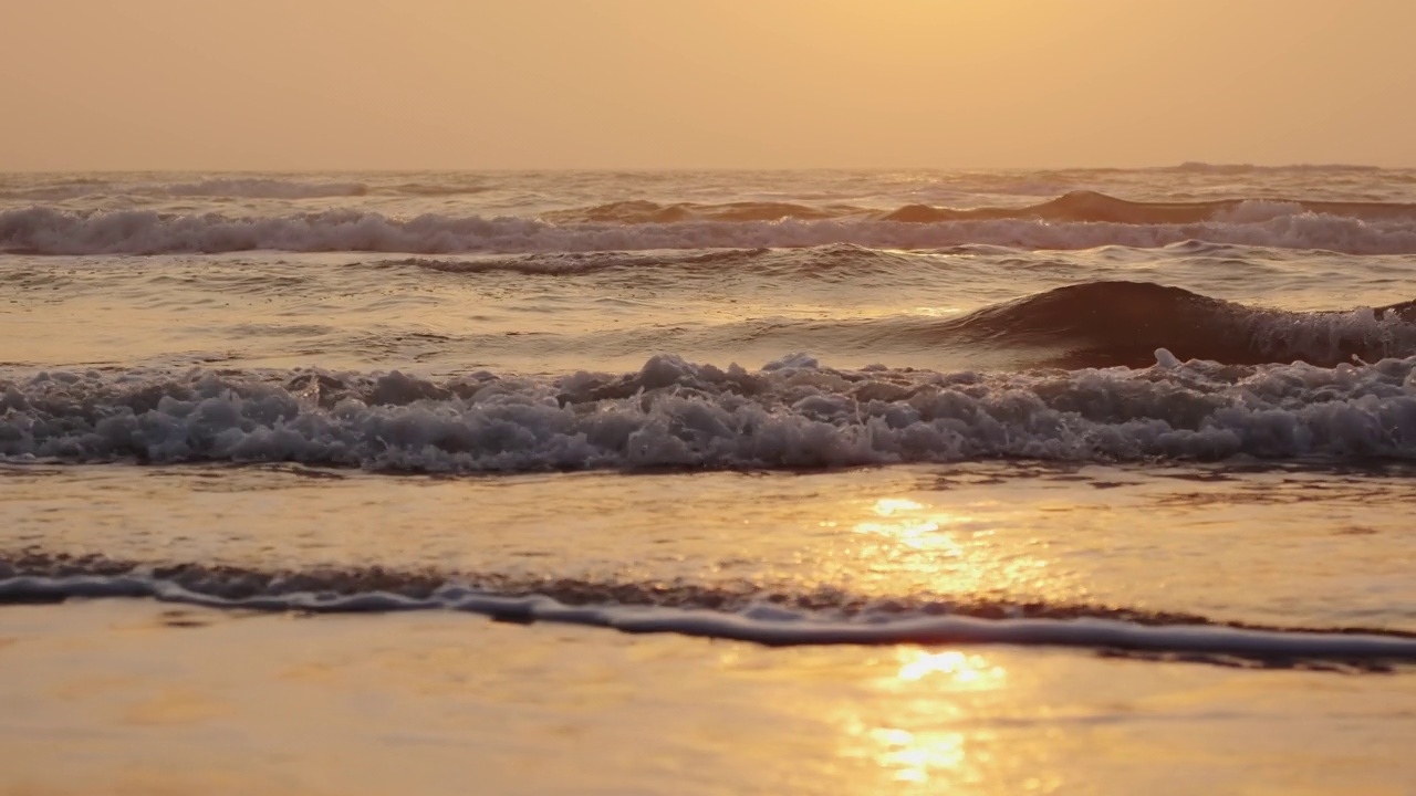 日出时海浪拍打海岸的特写。慢动作镜头视频下载