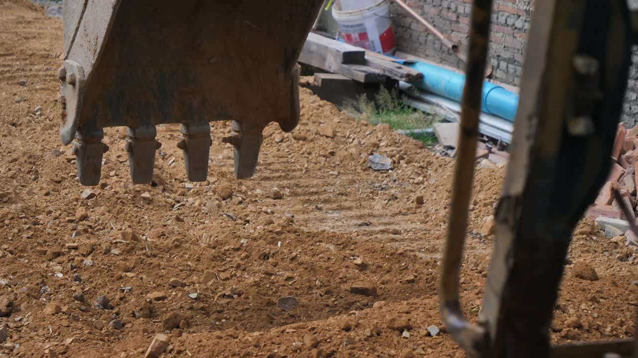 挖掘机的铲斗在挖掘，捡起泥土，视频素材
