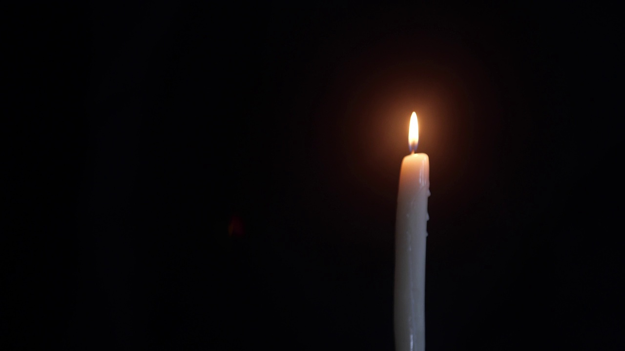 蜡烛在黑色背景上单独燃烧，然后熄灭。Kopi空间，象征和概念的生与死，记忆，葬礼。视频下载