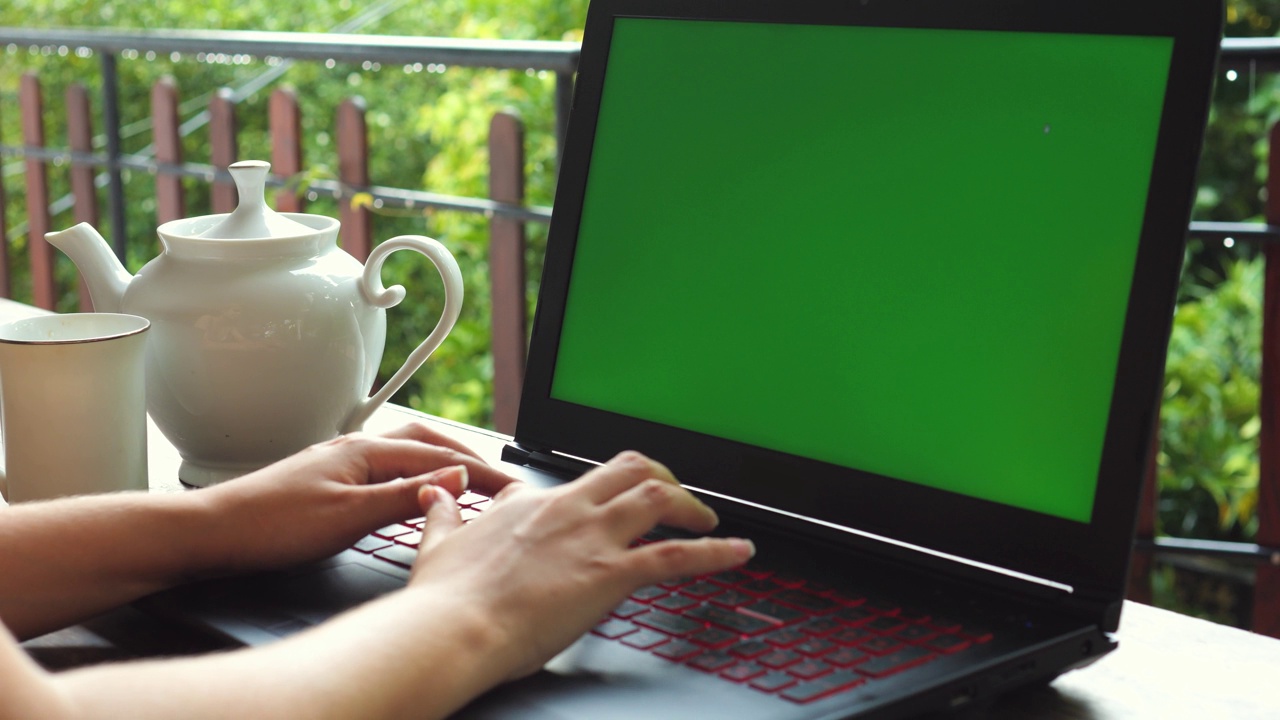 女性的手在绿色屏幕的笔记本电脑上打字。关闭了。视频下载