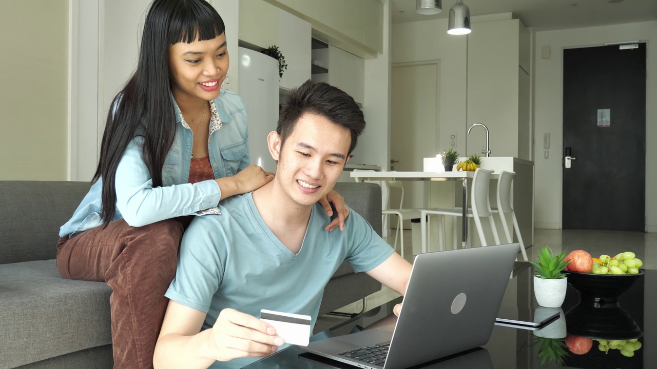 泛亚洲夫妇在家用信用卡在线支付订单视频素材