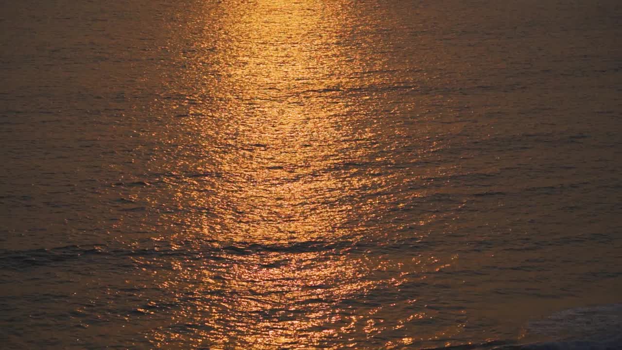 从印度果阿的拉玛角看到日落时的大海。阳光使海水在阳光下呈现橙色。自然日落海滩放松的背景。视频素材