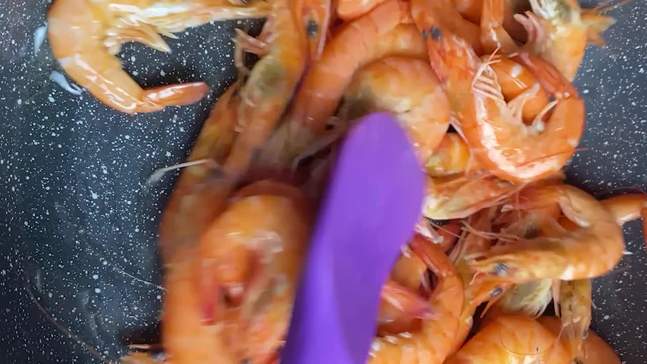 竖屏:在热锅中煮虾，煎海鲜的特写镜头运动。烩海鲜。将水倒入盛有虾的煎锅中视频素材