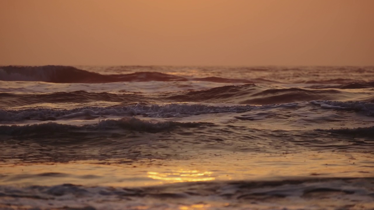 日出时，巨大的海浪冲击着海岸。慢动作镜头视频素材