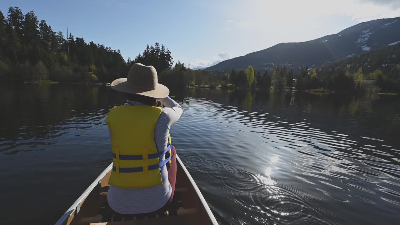 女子在美丽的山间湖泊上划独木舟视频下载
