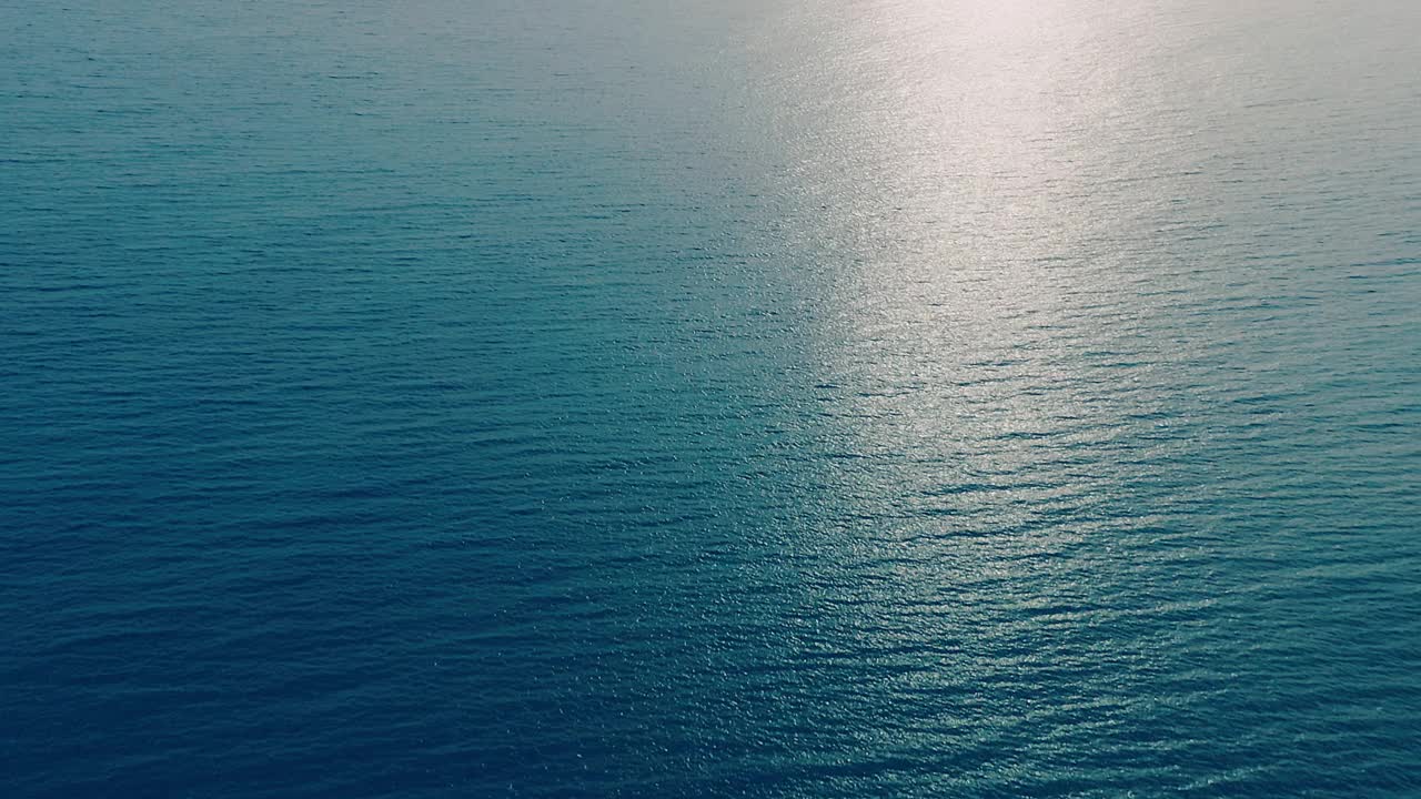 日落时海洋表面阳光路径的鸟瞰图视频下载