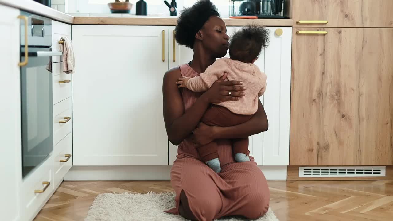 妈妈在家里的厨房里抱着并安慰着男婴视频下载