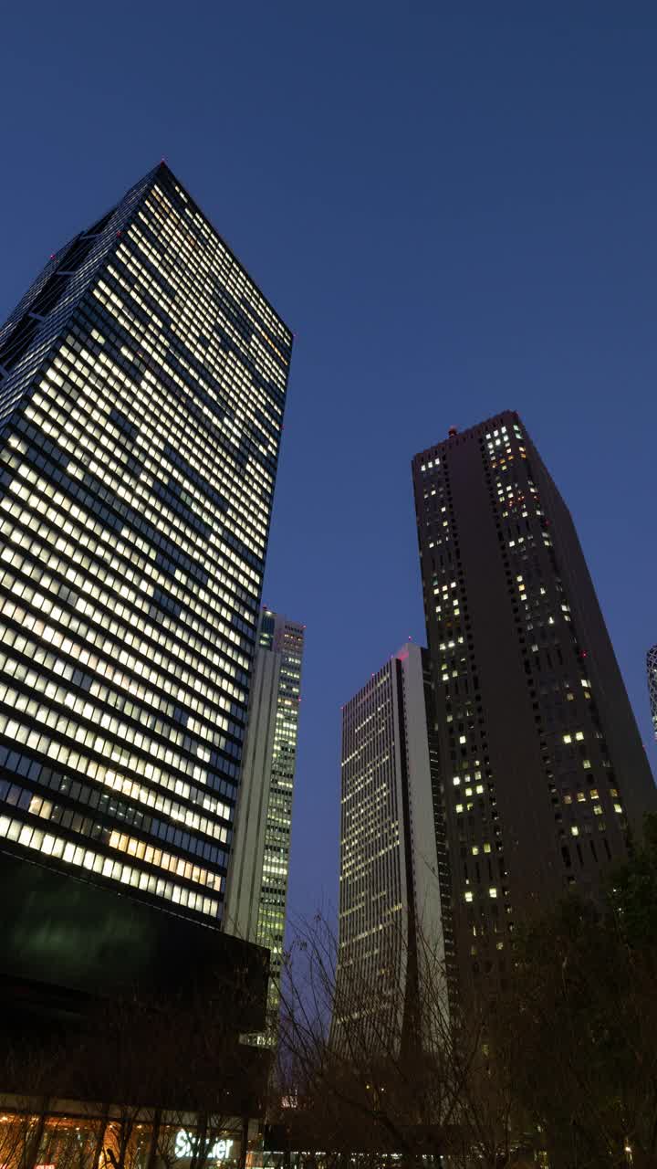 在夜晚仰望摩天大楼(放大):日本东京新宿视频下载