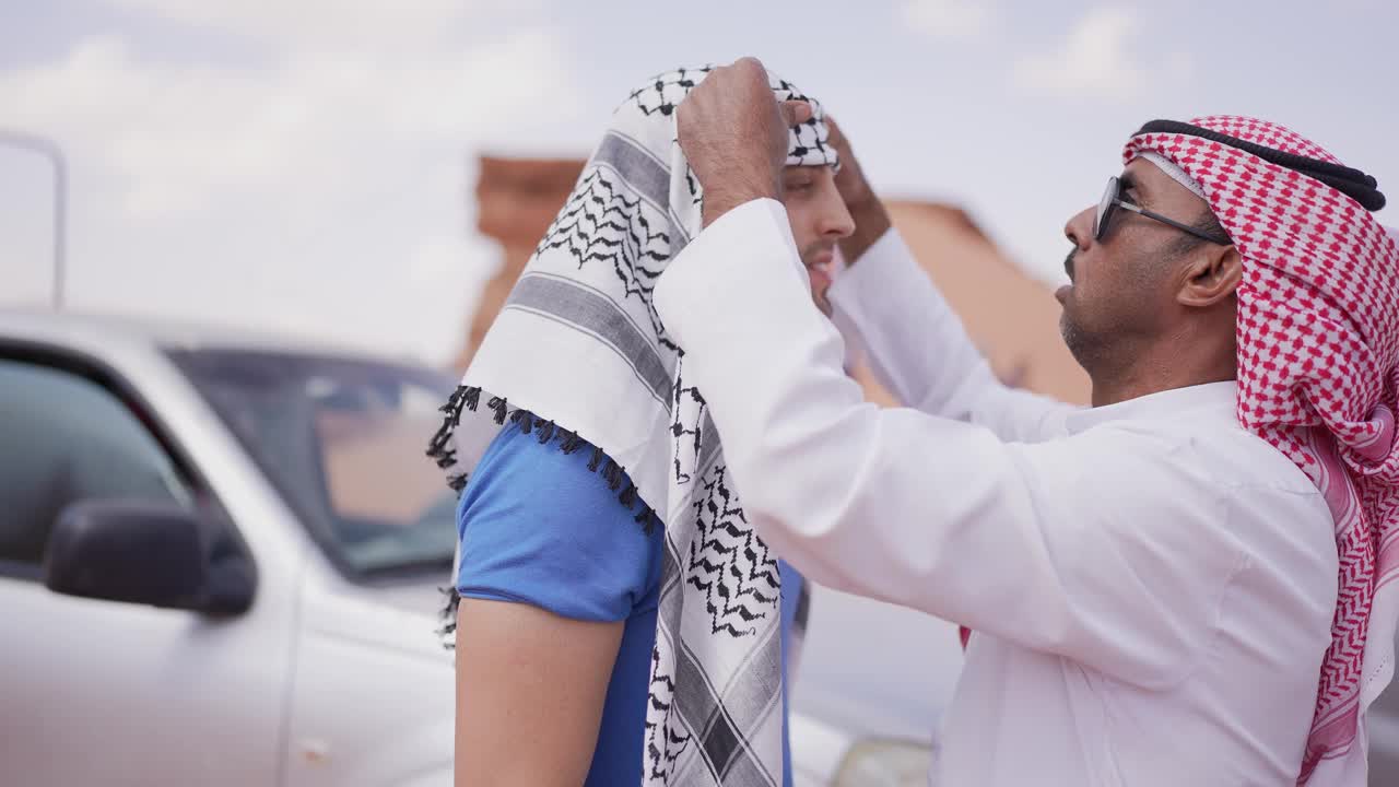中东男子帮助戴头巾的游客视频素材