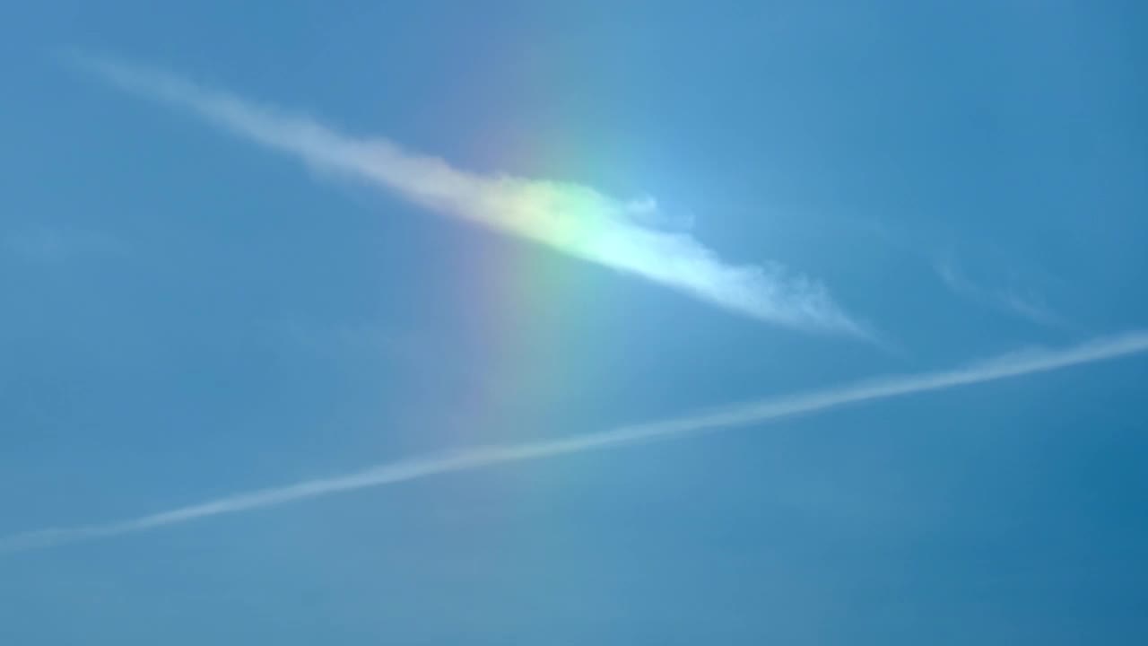 彩虹来自太阳的光环和蓝天上的云彩。间隔拍摄视频素材