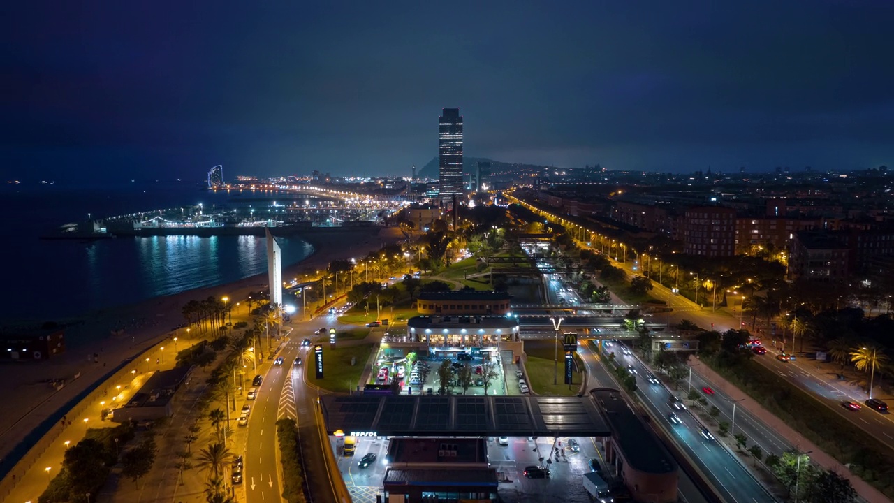 夜间照明飞行在巴塞罗那市著名的拥挤的海滩交通湾航拍全景4k延时西班牙视频下载