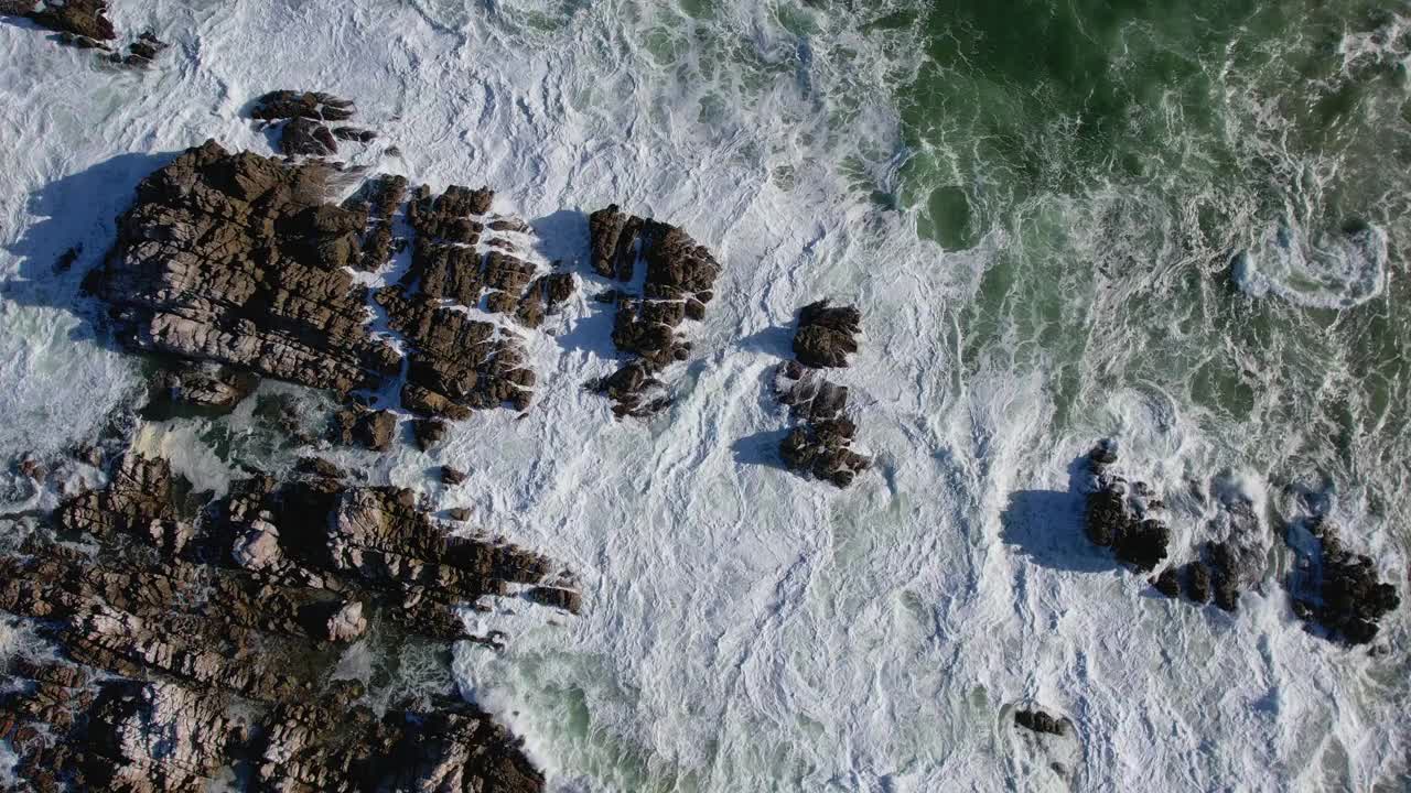 从上到下的海浪冲击岩石海岸线的视频视频素材