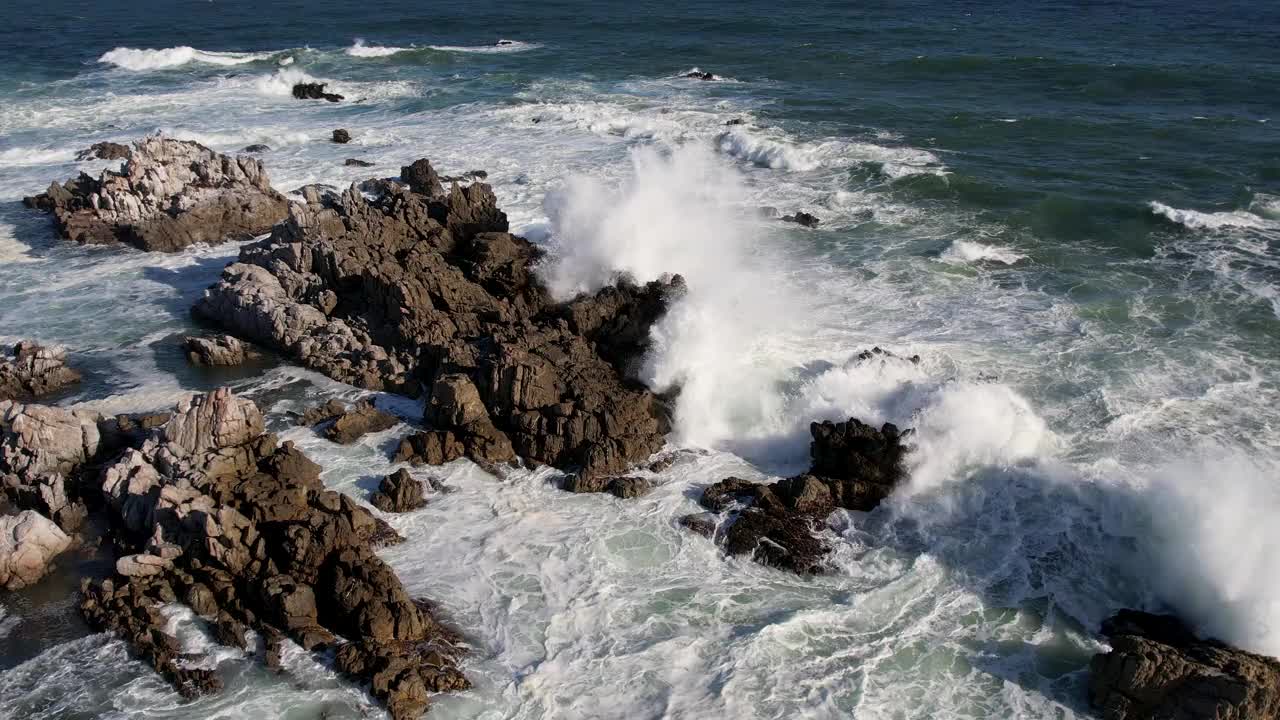 汹涌的海浪冲击着岩石嶙峋的海岸线视频素材