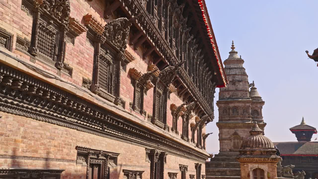 尼泊尔加德满都谷地巴克塔普尔杜巴广场上的五十五扇窗宫殿和远处的西迪拉克希米神庙视频素材