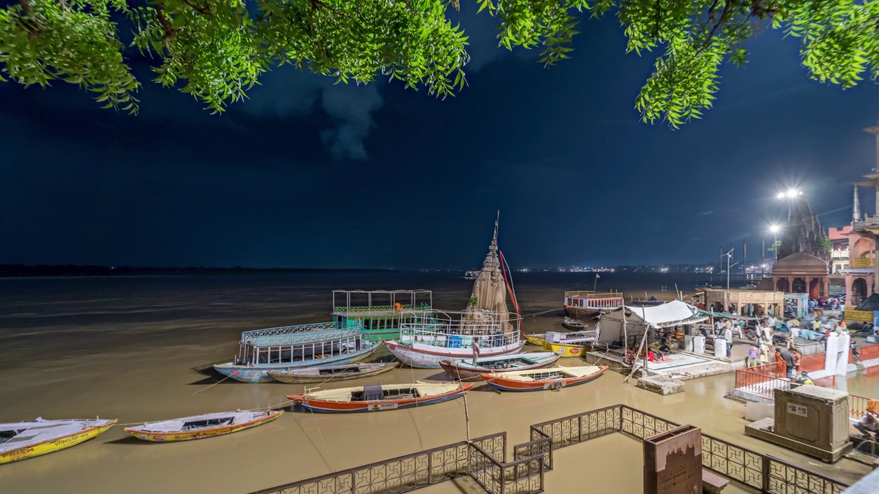 印度北方邦瓦拉纳西，夜晚，瓦拉纳西市著名圣山上的寺庙、船只和信徒的时间流逝视频下载