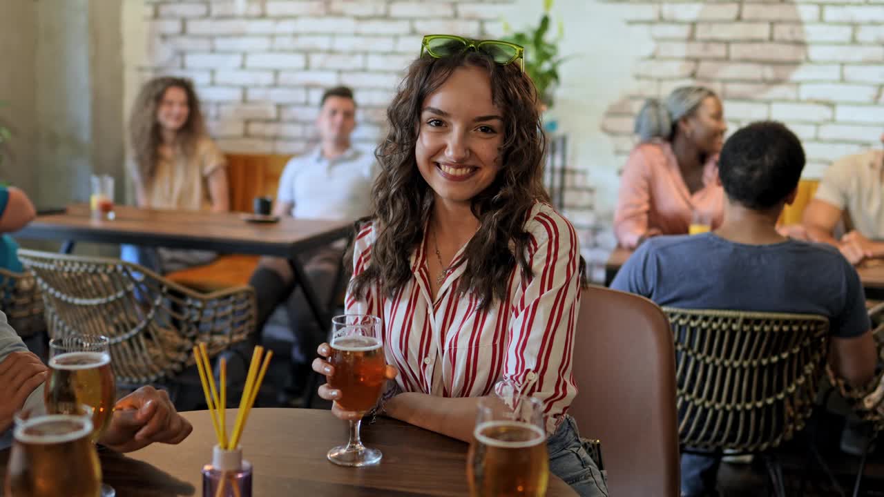 一个年轻女子在酒吧喝啤酒的画像视频素材