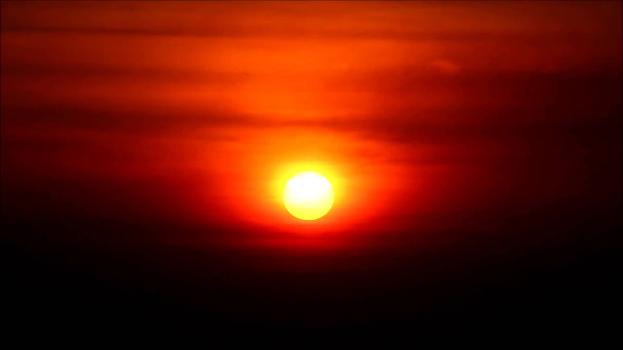 明亮的金色太阳落在红色的夜空上的延时镜头视频素材