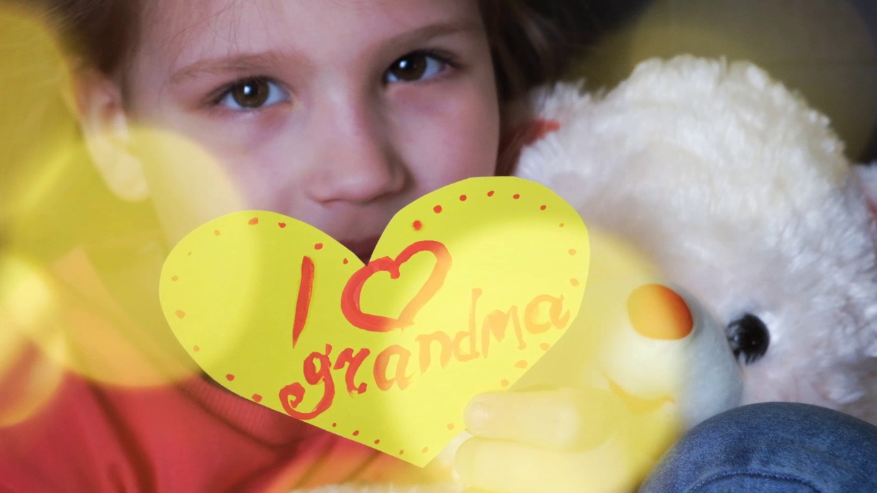 漂亮可爱的小女孩手持心形贺卡祝贺奶奶视频下载
