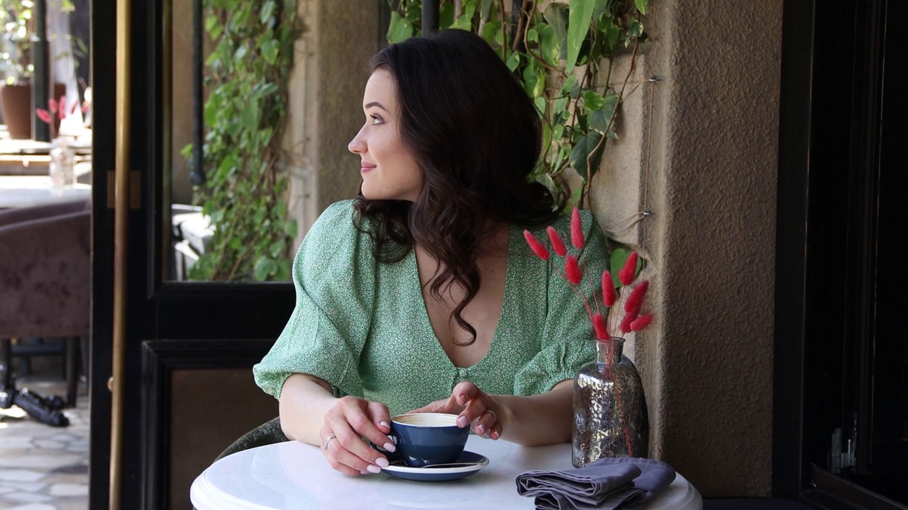 夏天，女孩在街边咖啡馆喝咖啡。4 k的决议视频下载
