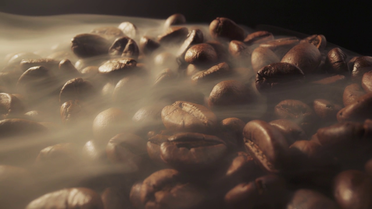 咖啡豆在烘焙过程中的滑块镜头。烟来自新鲜的咖啡籽。微距拍摄，4K视频素材