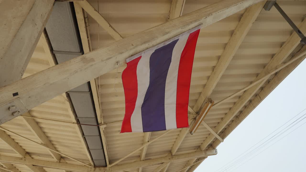 移动的泰国国旗悬挂在木质屋顶支撑梁上，慢镜头拍摄视频素材