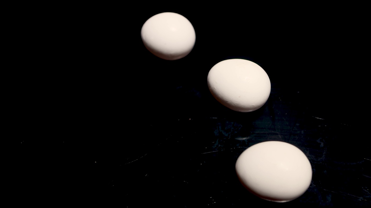 白色的复活节鸡蛋在黑色的桌子上旋转。完美的复活节，这些鸡蛋可以用于各种烹饪食谱。这些刚下蛋的鸡，一定会更美味。视频下载