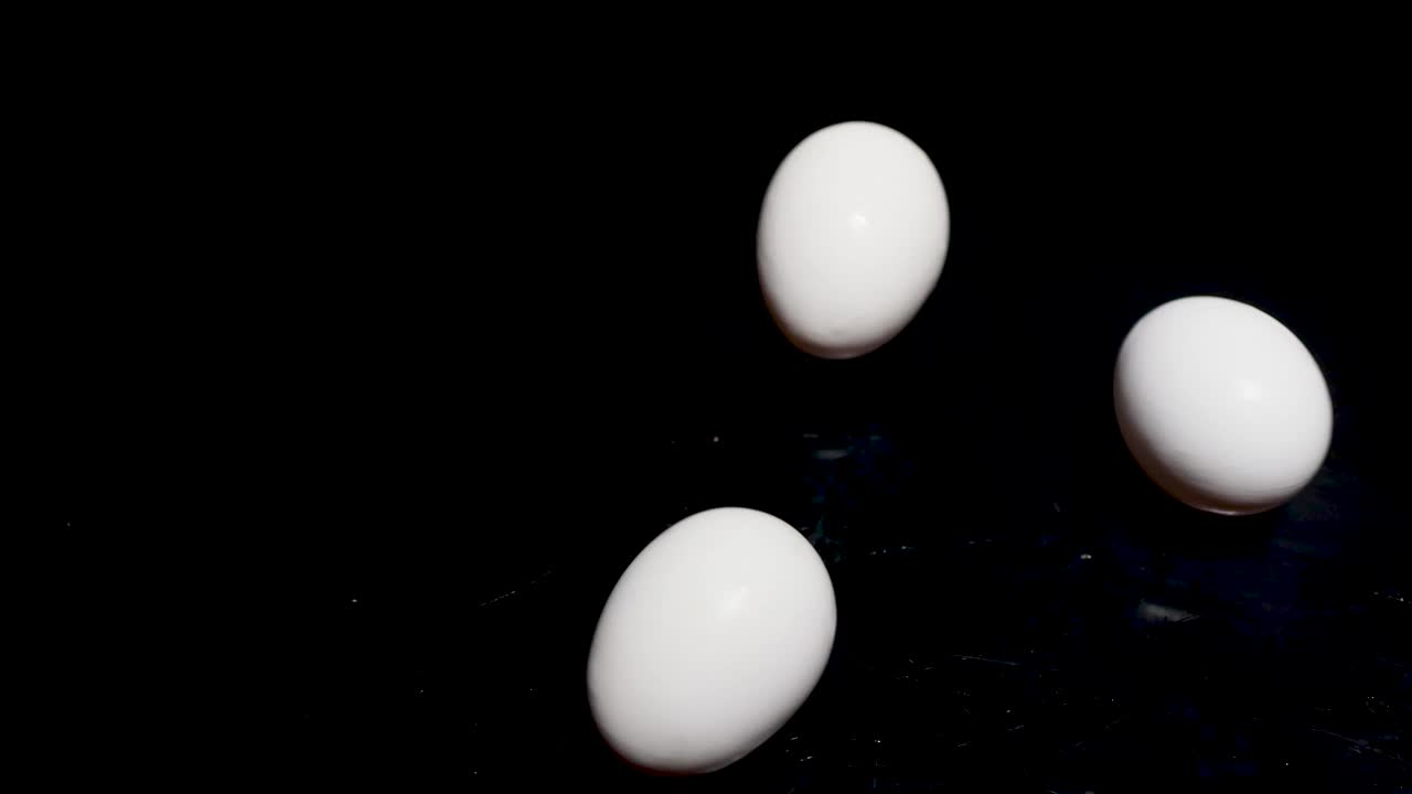 白色的复活节鸡蛋在黑色的桌子上旋转。完美的复活节，这些鸡蛋可以用于各种烹饪食谱。这些刚下蛋的鸡，一定会更美味。视频素材