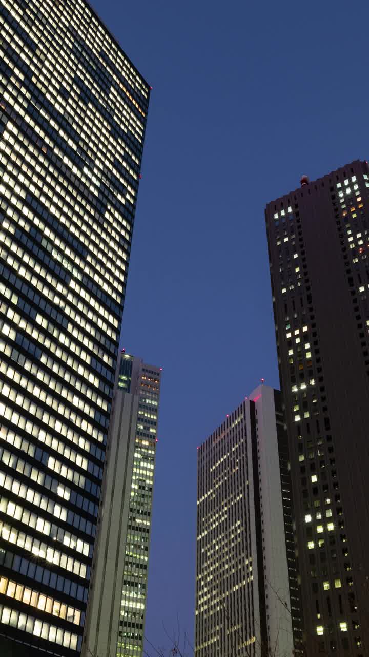 在夜晚仰望摩天大楼(垂直延时/缩小):日本东京新宿视频下载
