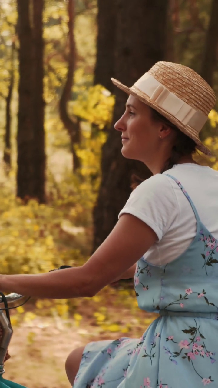 一位女士在城市公园骑着复古的自行车，带着篮子。垂直视频视频下载