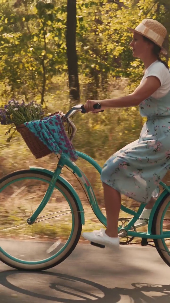 在阳光下的公园里骑着复古自行车的女人。垂直视频视频下载