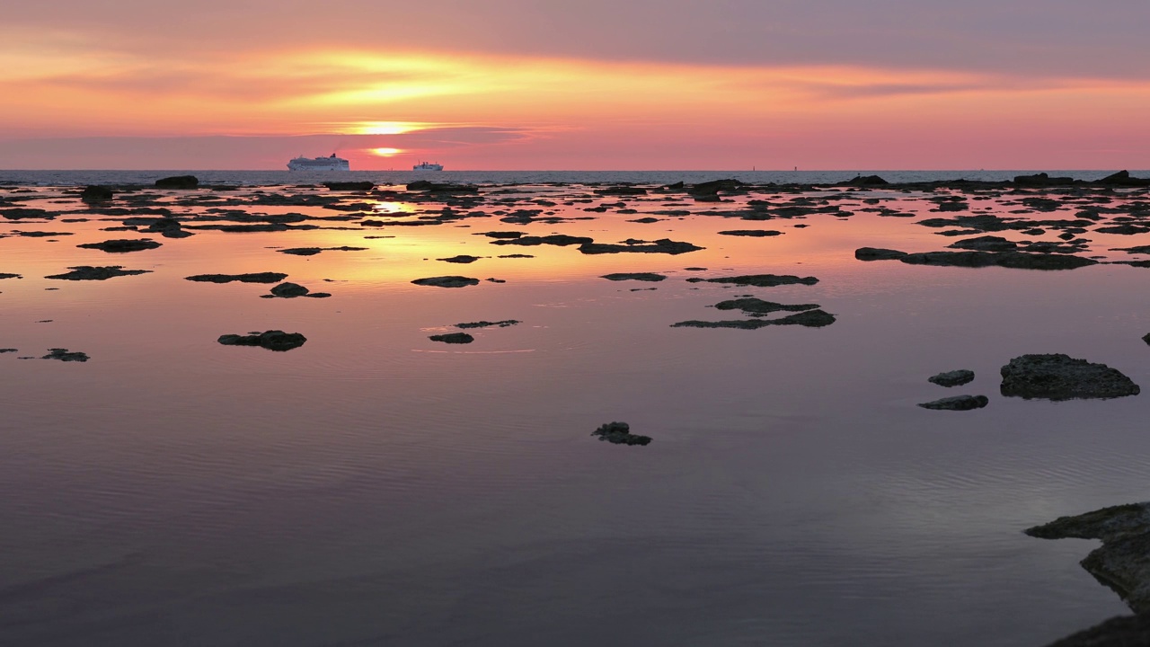 日落反射在海面上，就像镜子里的岩石出现在水面上视频下载
