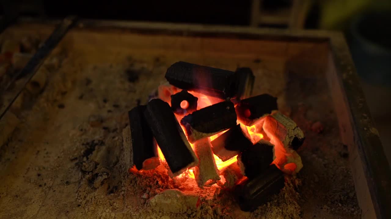 木炭在烤架里燃烧着。视频素材