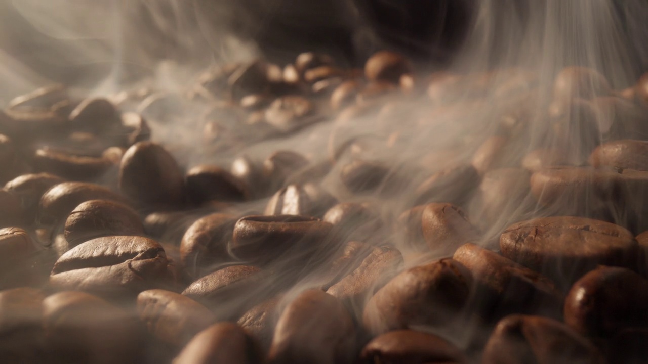 烟来自新鲜的咖啡籽。在黑背景下用烟熏咖啡豆视频素材