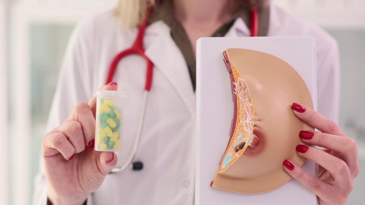 妇科医生拿着乳房解剖模型和一罐药丸在诊所的特写4k电影视频下载
