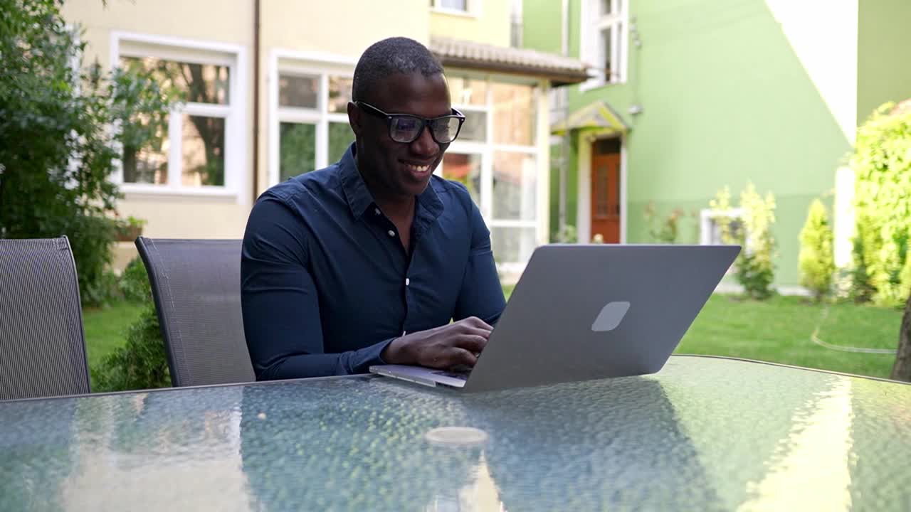 一个企业家坐在花园里用他的笔记本电脑视频素材