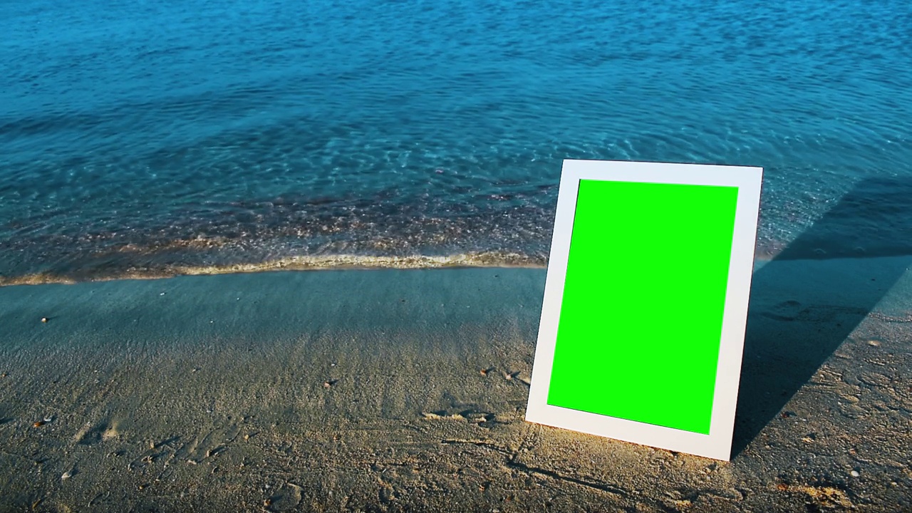 白色的相框立在海边的沙滩上。视频下载