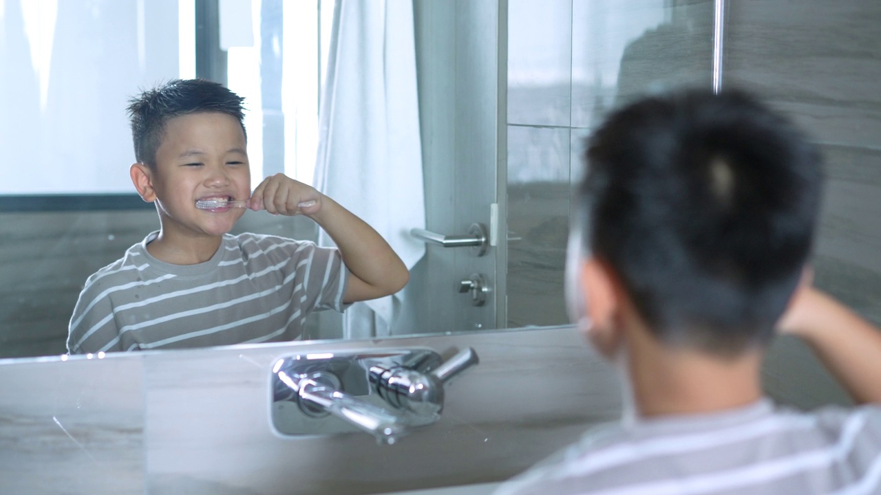 亚洲小孩在洁白干净的浴室里刷牙。日常健康和牙齿护理的概念视频下载