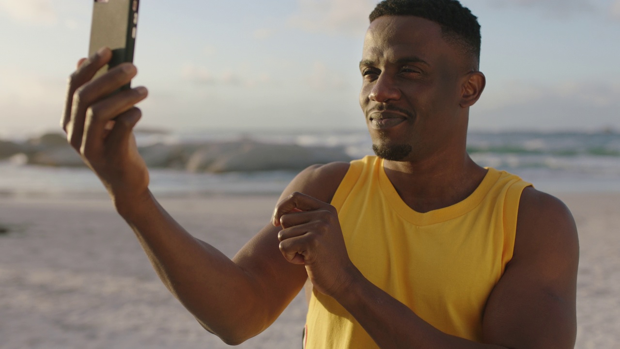 迷人的年轻非洲裔美国人在海滩上用手机自拍视频素材