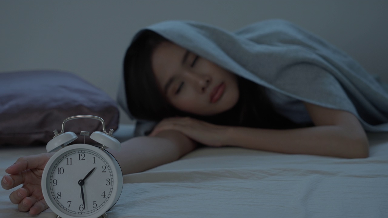 亚洲女性在床上睡得很晚，试图入睡，失眠，失眠或害怕在噩梦中，看起来悲伤，担心和压力。半夜醒来时感到疲倦、头痛或偏头痛。视频下载