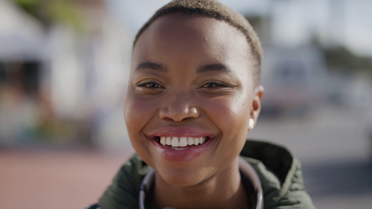 年轻美丽的非裔美国妇女的特写肖像，在充满活力的城市海滨享受夏天，微笑快乐视频下载