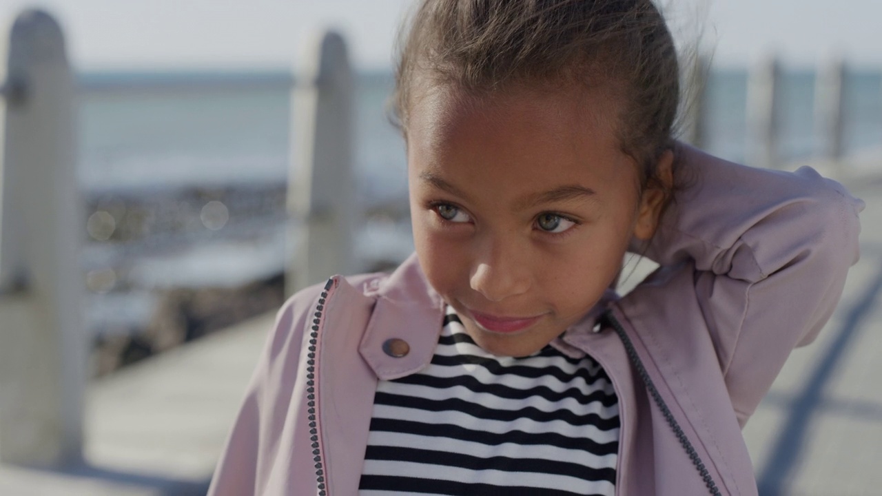 年轻可爱的混血女孩在海边的背景下微笑着享受暑假视频下载