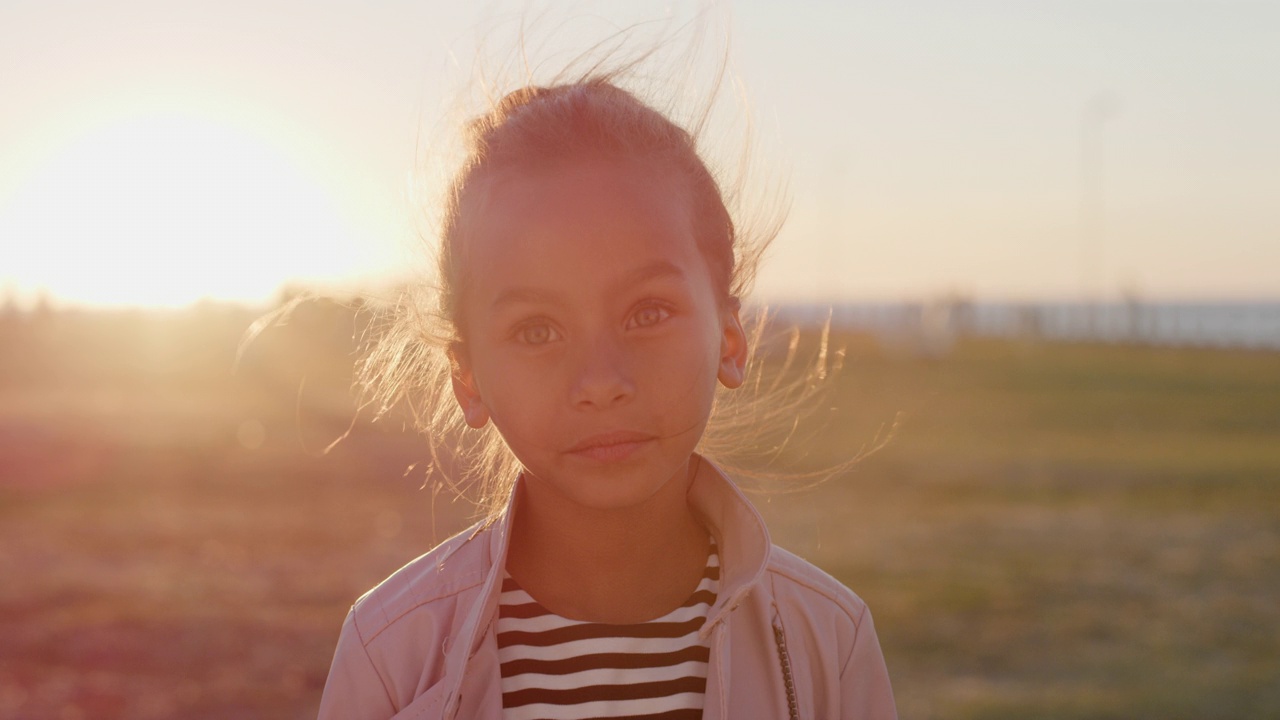 肖像年轻的小混血女孩在美丽的公园享受暑假，在日落真人系列视频素材