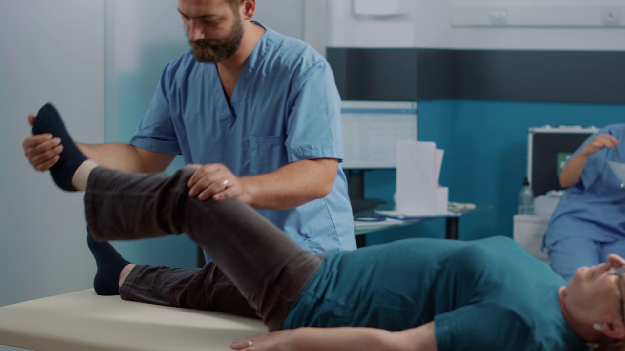 男治疗师正在做矫形运动伸展腿部肌肉视频素材