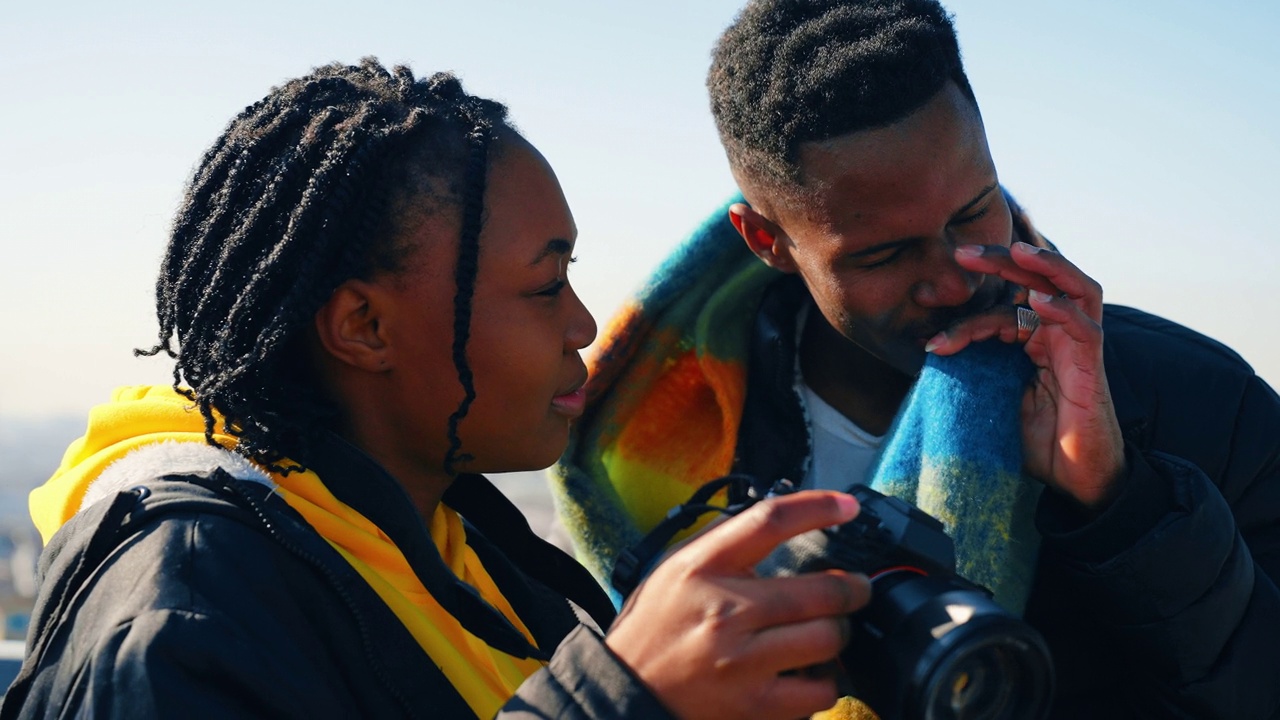年轻漂亮的非裔美国女游客在男性朋友面前摆姿势拍照视频素材