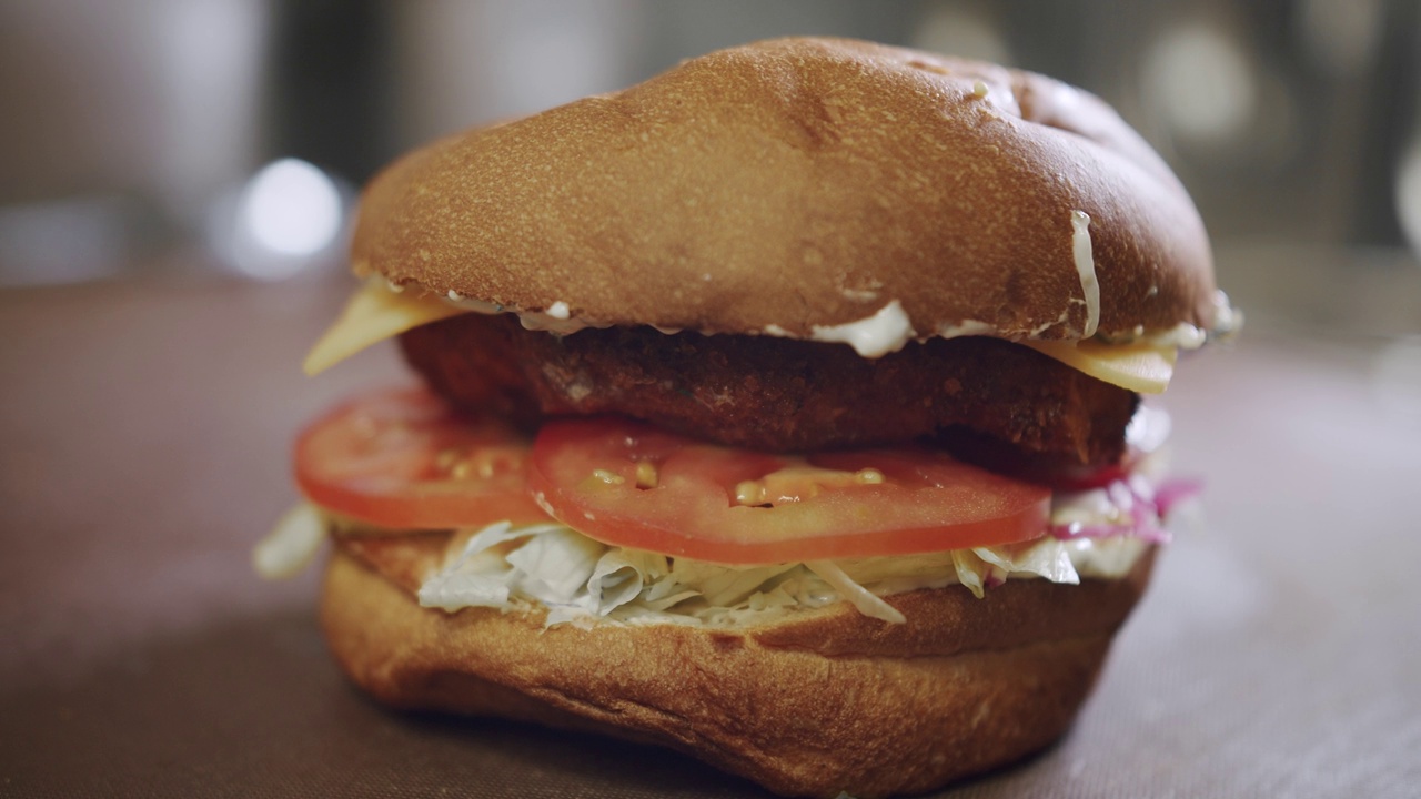 美味的快餐概念。汉堡配肉饼，西红柿，黄瓜，生菜。视频素材
