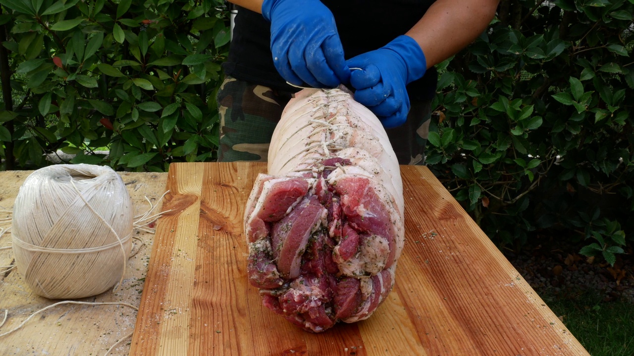 屠夫把肉卷起来准备烤猪肉视频下载