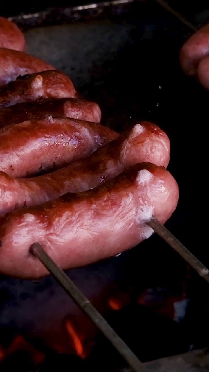 在巴西烤肉架上，烤肉串上的猪肉香肠。视频下载