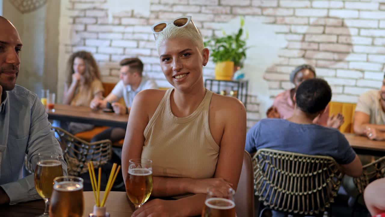 一个年轻女子在酒吧喝啤酒的画像视频素材