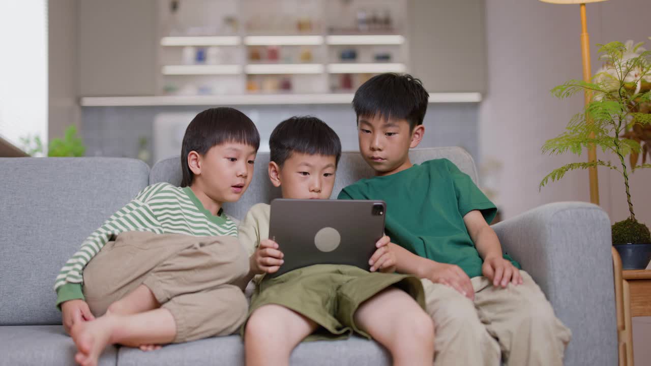 亚洲兄弟在家里用平板电脑看视频视频素材