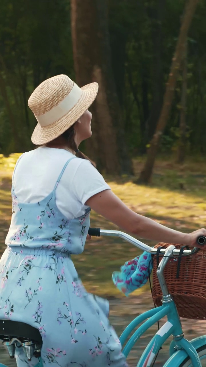 微笑迷人的女人骑着复古复古的自行车在公园里。垂直视频视频下载